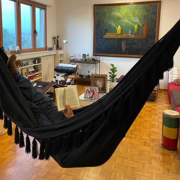 hamaca chinchorro wayuu negro en un salon de una casa leyendo