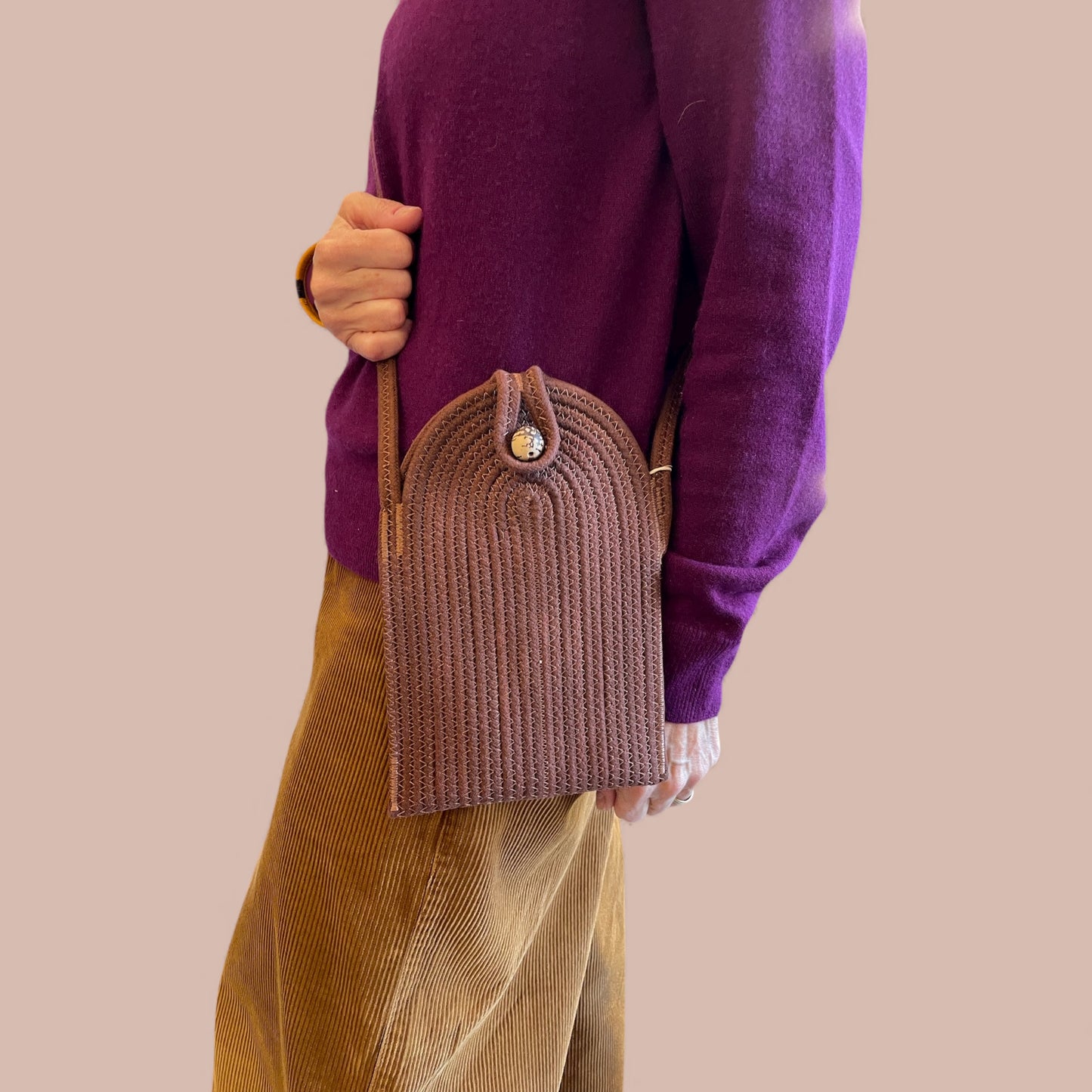 Portacellulare tracolla marrone vista laterale dettaglio chiusura bottone artigianale, indossata